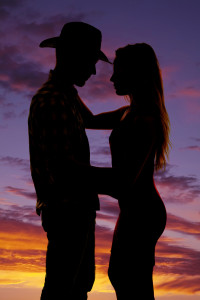 a silhouette of a cowboy holding on to his lady.