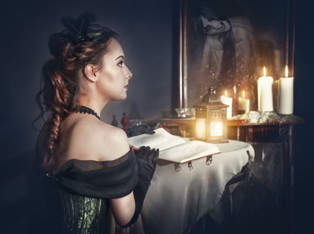 Woman with book in retro dress and ghost in the mirror